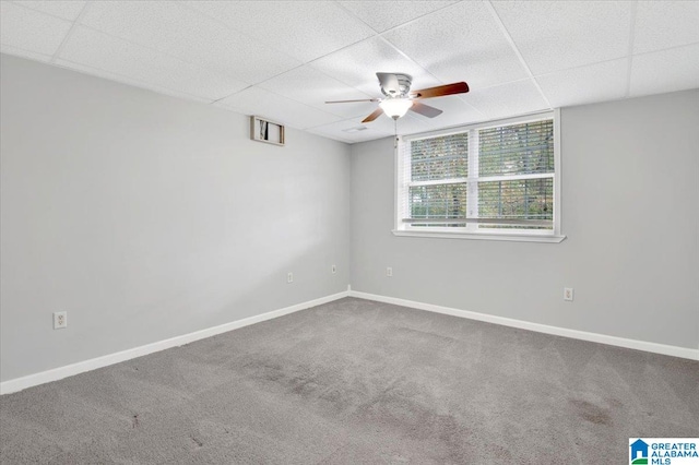 carpeted spare room featuring a drop ceiling and ceiling fan