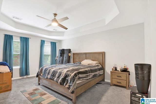 bedroom featuring a tray ceiling, ceiling fan, and light carpet