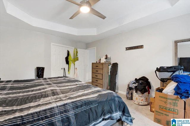 bedroom featuring carpet, ceiling fan, and a tray ceiling