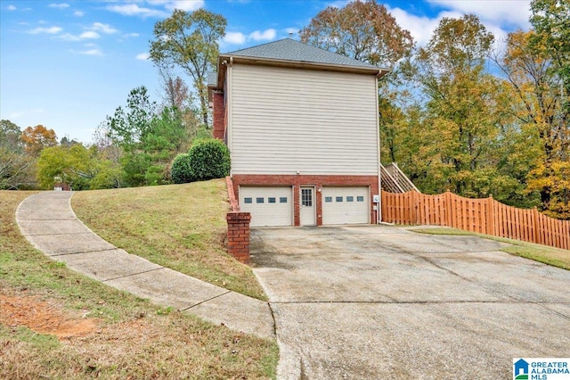 view of side of property featuring a lawn and a garage