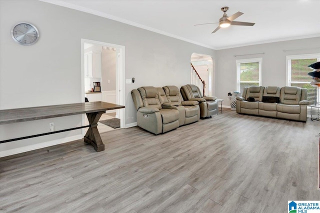 living room featuring ceiling fan, crown molding, and light hardwood / wood-style flooring