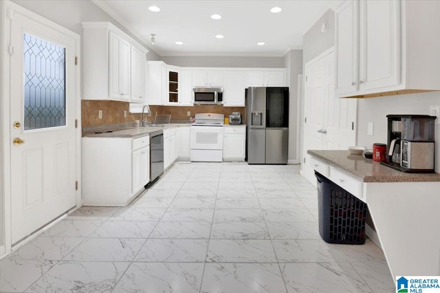 kitchen with decorative backsplash, light stone countertops, stainless steel appliances, crown molding, and white cabinetry