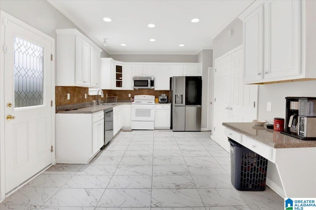 kitchen with white cabinets, stainless steel appliances, stone counters, and sink