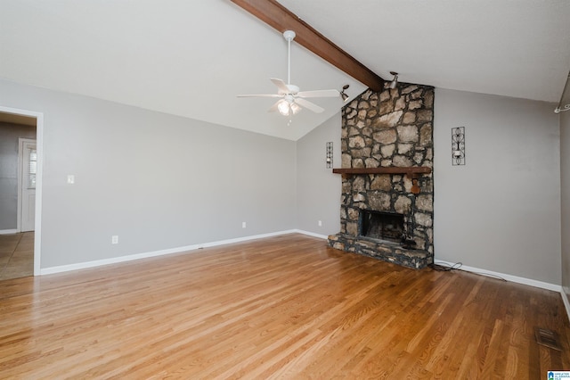 unfurnished living room with a fireplace, wood-type flooring, lofted ceiling with beams, and ceiling fan