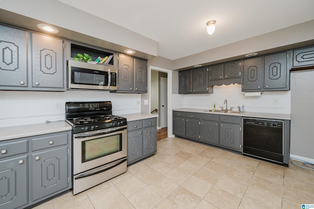 kitchen featuring gray cabinets, sink, light tile patterned floors, and stainless steel appliances