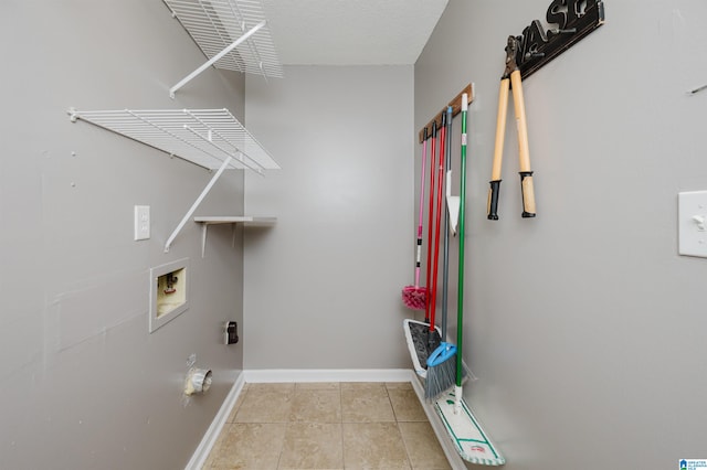 laundry room with light tile patterned floors, washer hookup, and a textured ceiling