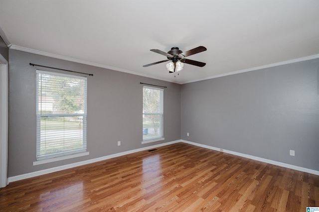 empty room with crown molding, hardwood / wood-style floors, and a healthy amount of sunlight