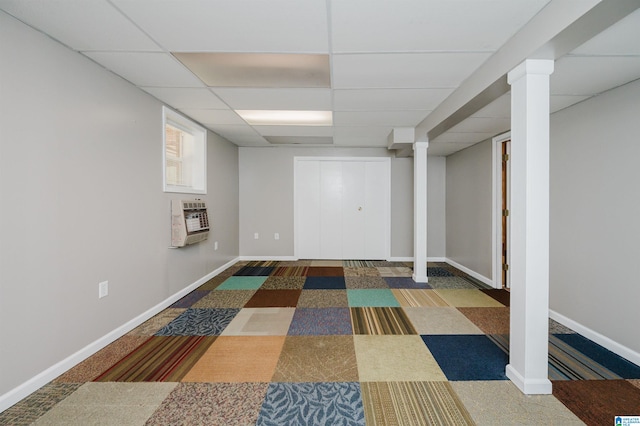 basement with heating unit, a drop ceiling, and dark carpet