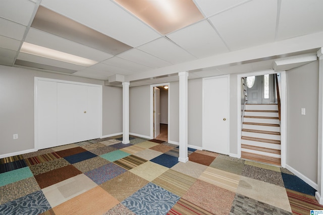 basement with dark colored carpet and a paneled ceiling