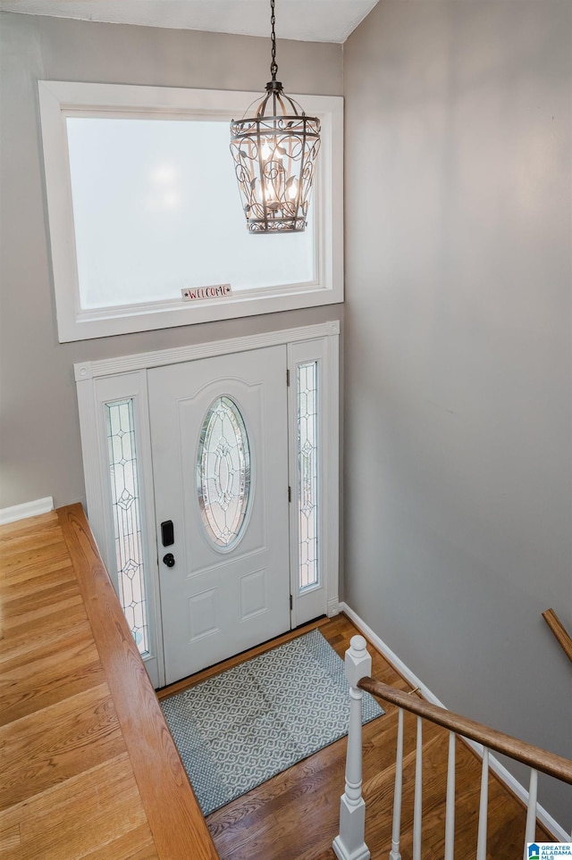 foyer with a wealth of natural light, hardwood / wood-style floors, and a chandelier