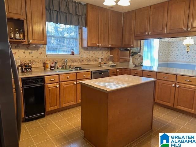 kitchen with light tile patterned floors, dishwasher, sink, and a kitchen island