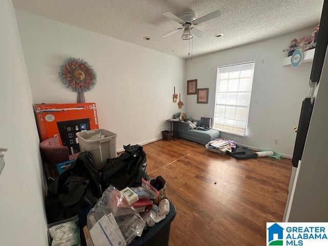 miscellaneous room with wood-type flooring, a textured ceiling, and ceiling fan