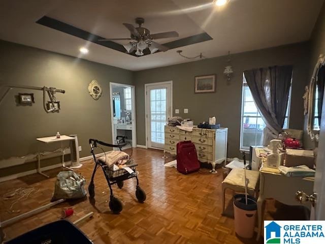 sitting room featuring ceiling fan and parquet flooring