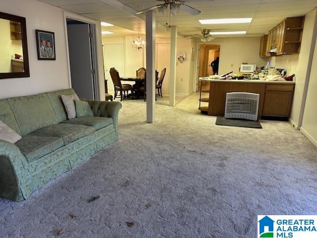 carpeted living room with a paneled ceiling and ceiling fan with notable chandelier