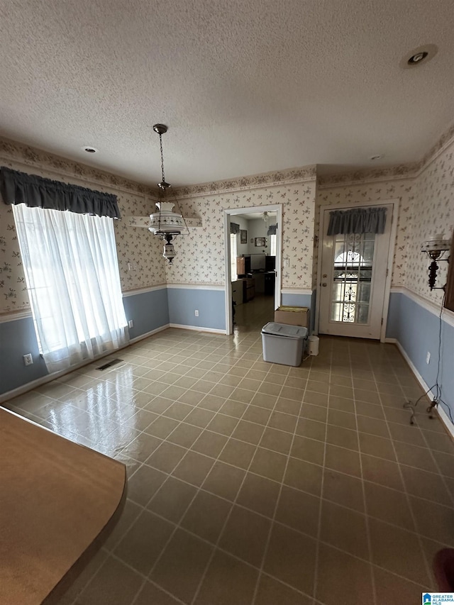 interior space with a textured ceiling and tile patterned floors