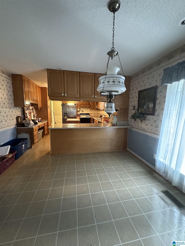 kitchen featuring stainless steel fridge with ice dispenser, light tile patterned flooring, kitchen peninsula, and decorative light fixtures