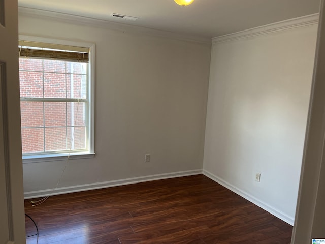 empty room with dark hardwood / wood-style flooring and ornamental molding