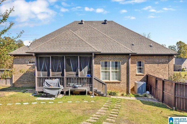 back of property featuring a lawn, central AC, and a sunroom