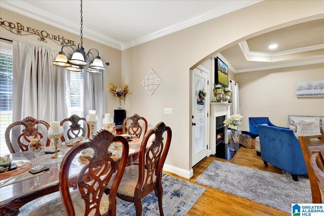 dining room featuring hardwood / wood-style flooring, an inviting chandelier, and ornamental molding