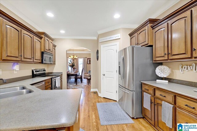 kitchen featuring appliances with stainless steel finishes, light hardwood / wood-style floors, crown molding, and sink