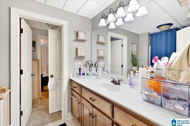 bathroom featuring a paneled ceiling and vanity