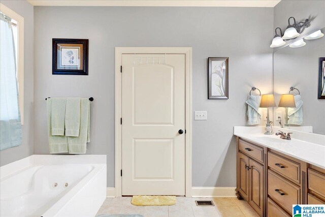 bathroom with tile patterned floors, a tub, and vanity