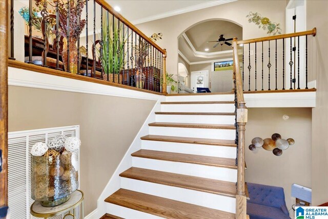 staircase with ceiling fan and crown molding