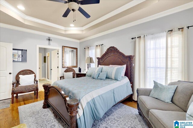 bedroom with multiple windows, ceiling fan, light hardwood / wood-style floors, and ornamental molding