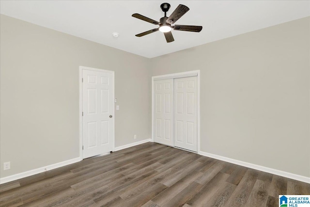 unfurnished bedroom featuring dark hardwood / wood-style floors, ceiling fan, and a closet