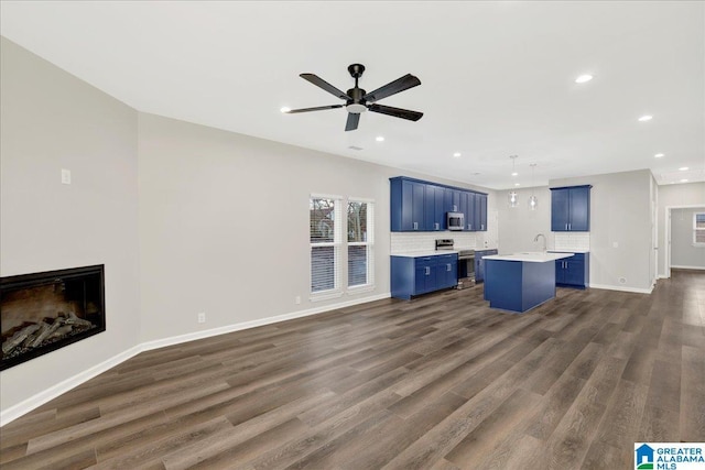 unfurnished living room with dark hardwood / wood-style flooring, sink, and ceiling fan