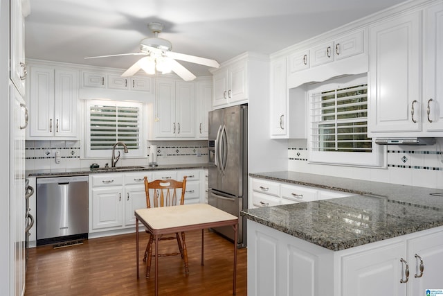 kitchen with stainless steel appliances, white cabinetry, and tasteful backsplash