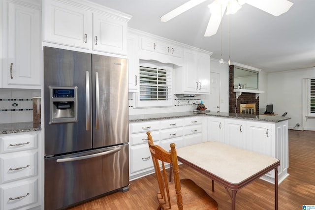 kitchen featuring tasteful backsplash, dark stone countertops, white cabinetry, and stainless steel refrigerator with ice dispenser