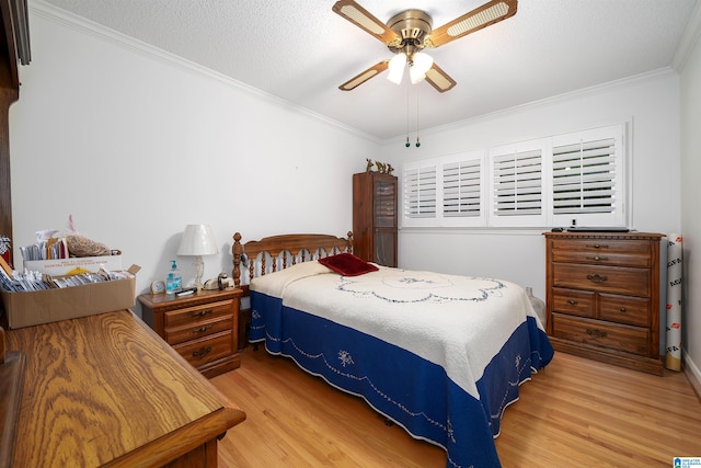 bedroom with hardwood / wood-style floors, a textured ceiling, ceiling fan, and ornamental molding