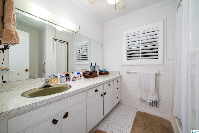 bathroom featuring vanity, tile patterned floors, tile walls, and ornamental molding