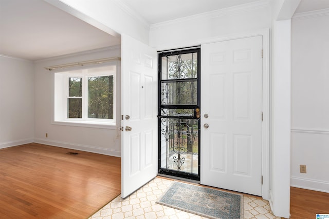 entrance foyer with light hardwood / wood-style floors and crown molding