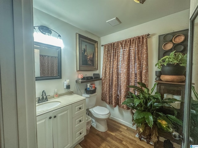 bathroom featuring toilet, wood finished floors, and vanity