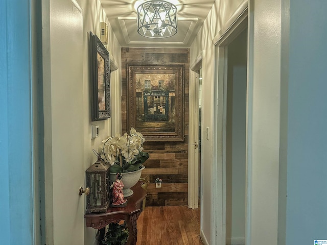 hallway featuring dark wood finished floors and a notable chandelier