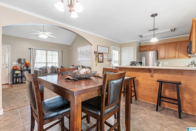 tiled dining area with vaulted ceiling, ceiling fan, and ornamental molding