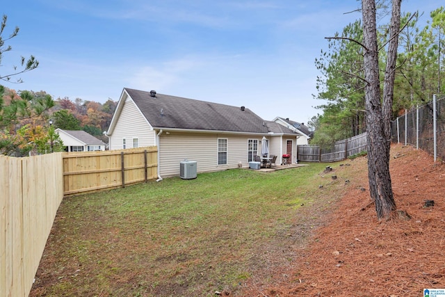 rear view of property with a lawn, central AC, and a patio area