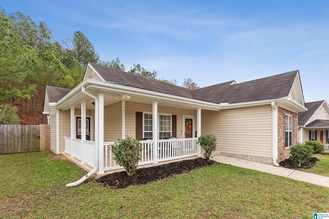 ranch-style home featuring covered porch and a front yard