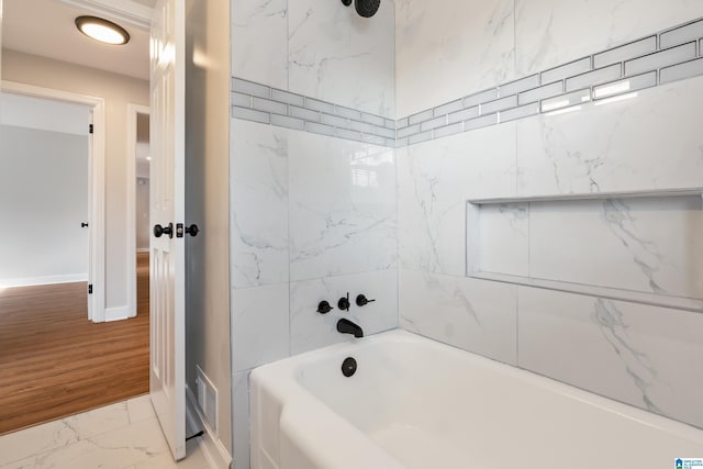 bathroom with hardwood / wood-style flooring and tiled shower / bath