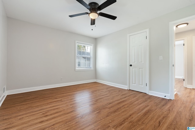 empty room with hardwood / wood-style floors and ceiling fan