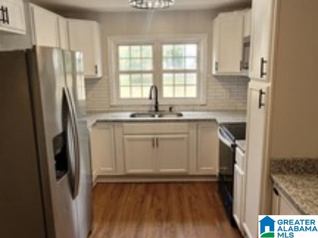 kitchen featuring white cabinets, black range with electric stovetop, sink, tasteful backsplash, and stainless steel fridge with ice dispenser