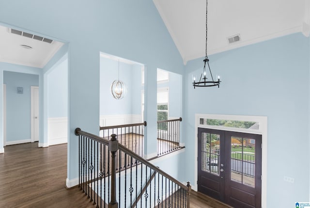 interior space with dark wood-type flooring, a wealth of natural light, french doors, and a chandelier