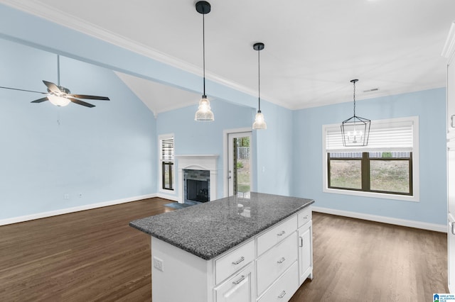 kitchen with a wealth of natural light, white cabinets, hanging light fixtures, and dark hardwood / wood-style floors