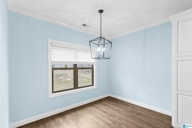 unfurnished dining area featuring a chandelier, crown molding, and wood-type flooring