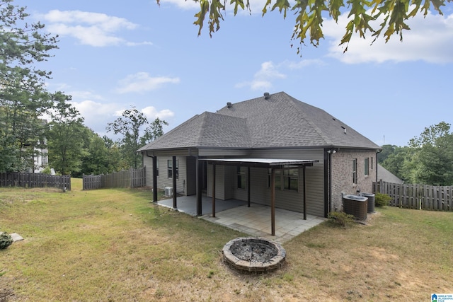 rear view of house with a lawn, central AC unit, and a patio