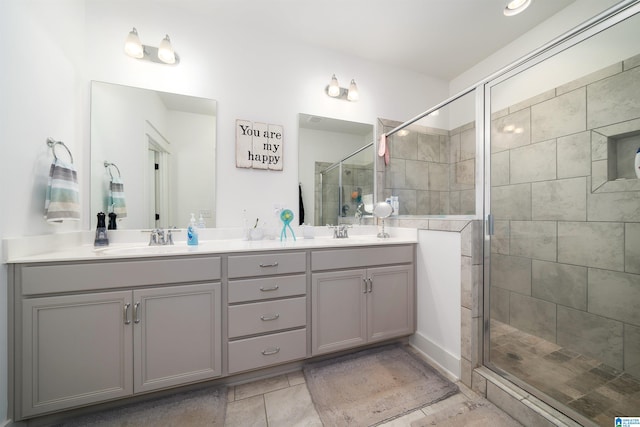 bathroom featuring tile patterned flooring, vanity, and a shower with door