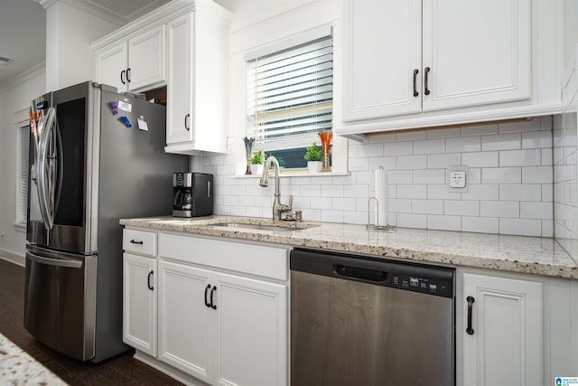 kitchen featuring white cabinets, sink, ornamental molding, light stone counters, and stainless steel appliances