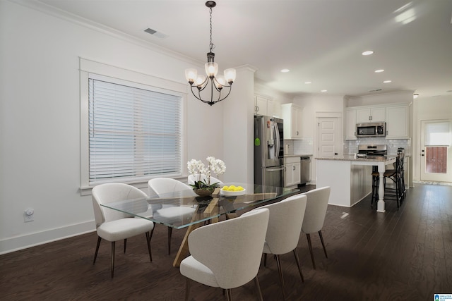 dining room featuring crown molding, dark wood-type flooring, and a notable chandelier